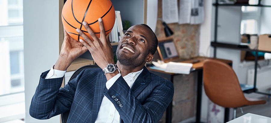 Vereinsmanager im Anzug hält einen Basketball